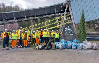 Carmeuse employees (+/- 15) in front of a plant, with a lot of collected trash bags