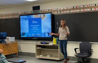 Carmeuse employee talking in a Class Room environment. On the screen of the TV behind her, you see a Carmeuse presentation.