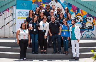 Around 15 Brazilian volunteers smiling and posing on a stair case.