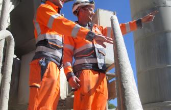 2 engineers wearing full PPE's on a Carmeuse plant pointing at something outside the picture