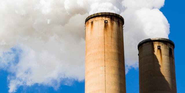 Two smoke stacks with steam coming out